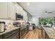 The kitchen features stainless steel appliances, granite counters and an open view to the living room and pool at 11125 Shelter Cove Loop, New Port Richey, FL 34654