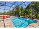 Inviting private screened pool with waterfall feature and lush landscaping at 11125 Shelter Cove Loop, New Port Richey, FL 34654