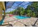 Enclosed pool with paver deck, waterfall, and lush landscaping at 11125 Shelter Cove Loop, New Port Richey, FL 34654