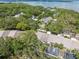 Aerial view of a neighborhood surrounded by trees and overlooking the water at 1136 Thayer St, Safety Harbor, FL 34695