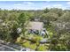 Aerial view showcasing the home's backyard with patio, garden, and surrounding trees at 1136 Thayer St, Safety Harbor, FL 34695
