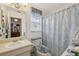 Bathroom featuring patterned shower curtain, white vanity, and a window with natural light at 1136 Thayer St, Safety Harbor, FL 34695