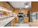 Kitchen features stainless steel appliances, wood cabinets, and granite countertops at 1136 Thayer St, Safety Harbor, FL 34695