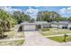 Aerial view of a home with a long driveway, attached garage, and a well-maintained front yard at 1403 Tallahassee Dr, Tarpon Springs, FL 34689
