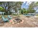 Expansive backyard with a fire pit, seating, and a glimpse of the pool beyond, ideal for outdoor gatherings at 1403 Tallahassee Dr, Tarpon Springs, FL 34689