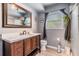 Traditional bathroom featuring dark-stained wooden vanity, neutral walls, and a framed mirror at 1403 Tallahassee Dr, Tarpon Springs, FL 34689