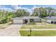 Charming single-story home with stone accents, mature trees, and a well-manicured front yard at 1403 Tallahassee Dr, Tarpon Springs, FL 34689