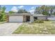 Well-maintained single-story home with stone detailing, a manicured front yard, and an attached garage at 1403 Tallahassee Dr, Tarpon Springs, FL 34689