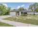 Charming single-story home showcasing stone accents, a well-manicured lawn, and an attached two-car garage at 1403 Tallahassee Dr, Tarpon Springs, FL 34689
