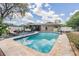 Inviting backyard oasis featuring a private pool, spacious deck, and comfortable seating area at 1403 Tallahassee Dr, Tarpon Springs, FL 34689