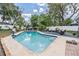 Inviting backyard pool with a spacious deck and lush landscaping, perfect for outdoor relaxation and entertainment at 1403 Tallahassee Dr, Tarpon Springs, FL 34689