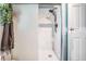 Elegant shower with marble-look tile, modern fixture, glass slider and white shower base at 1403 Tallahassee Dr, Tarpon Springs, FL 34689