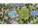 A bird's eye view showing the community pool, clubhouse, lawns, and a tennis court at 15420 Quail Woods Pl, Ruskin, FL 33573