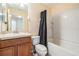 A bathroom featuring a vanity, toilet, bathtub and shower with white tile surround at 15420 Quail Woods Pl, Ruskin, FL 33573