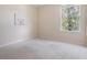 Bright bedroom with a view, neutral walls, carpet flooring, and natural light at 15420 Quail Woods Pl, Ruskin, FL 33573