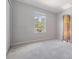 Bright bedroom with neutral walls, carpet flooring, and a window with natural light at 15420 Quail Woods Pl, Ruskin, FL 33573