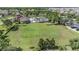 Aerial shot of a community clubhouse and pool area with palm trees and lush greenery at 15420 Quail Woods Pl, Ruskin, FL 33573