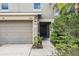 Close up of the exterior featuring a two-car garage and a covered front entryway at 15420 Quail Woods Pl, Ruskin, FL 33573