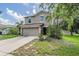 Charming two-story home featuring an attached garage and well-manicured front yard landscaping at 15420 Quail Woods Pl, Ruskin, FL 33573