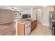 Open kitchen featuring tile flooring, stainless steel appliances, and a breakfast bar, seamlessly connected to the living area at 15420 Quail Woods Pl, Ruskin, FL 33573
