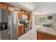 Bright kitchen showcasing stainless steel refrigerator, a range, and abundant wood cabinetry, complemented by a large sink at 15420 Quail Woods Pl, Ruskin, FL 33573