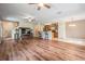 Spacious living room featuring hard wood flooring, ceiling fans, and an open floorplan at 15420 Quail Woods Pl, Ruskin, FL 33573
