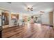Open-concept living room and kitchen with wood flooring, ceiling fans, and patio access at 15420 Quail Woods Pl, Ruskin, FL 33573