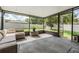 A covered and screened patio with wicker furniture and a view of the backyard at 15420 Quail Woods Pl, Ruskin, FL 33573
