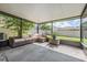 Covered and screened patio with wicker furniture and view of the backyard at 15420 Quail Woods Pl, Ruskin, FL 33573