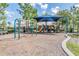 A colorful, shaded playground offering a swing set, slide, and climbing area for children at 15420 Quail Woods Pl, Ruskin, FL 33573