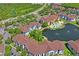Community aerial view featuring lush green landscaping, a pond, a pool, and a clubhouse, all near a major highway at 1640 Villa Capri Cir # 206, Odessa, FL 33556