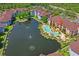 Aerial view of condo complex with large pond, fountain, and pool area surrounded by lush green landscape at 1640 Villa Capri Cir # 206, Odessa, FL 33556