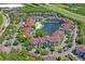 Community aerial view featuring lush green landscaping, a pond, a pool, and a clubhouse, all near a major highway at 1640 Villa Capri Cir # 206, Odessa, FL 33556