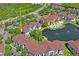 Community aerial view featuring lush green landscaping, a pond, a pool, and a clubhouse, all near a major highway at 1640 Villa Capri Cir # 206, Odessa, FL 33556