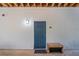 Exterior shot of a blue unit front door with black mat, wooden floors and a wall light at 1640 Villa Capri Cir # 206, Odessa, FL 33556
