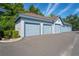 Row of garages with light blue doors, neutral siding and roof under a partly cloudy sky at 1640 Villa Capri Cir # 206, Odessa, FL 33556