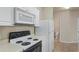 Close up of a white kitchen featuring electric range, microwave, and a white refrigerator at 1640 Villa Capri Cir # 206, Odessa, FL 33556