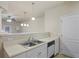 Neutral kitchen featuring stainless steel sink, white cabinets and a modern dishwasher at 1640 Villa Capri Cir # 206, Odessa, FL 33556
