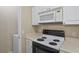 Close up of a white kitchen offering microwave, range, and tile floors at 1640 Villa Capri Cir # 206, Odessa, FL 33556