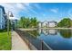 Apartment complex pond featuring black metal railings, green grass, and buildings in the background at 1640 Villa Capri Cir # 206, Odessa, FL 33556