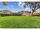 Expansive backyard with mature trees, green grass, and manicured hedges at 1810 Tamerlane Pl, Brandon, FL 33510