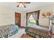 Bedroom featuring two twin beds with blue comforters, a wood door and a window at 1810 Tamerlane Pl, Brandon, FL 33510