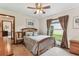 Bedroom features a comfortable bed with a ceiling fan, view outside, and connecting door at 1810 Tamerlane Pl, Brandon, FL 33510