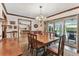 Dining room with hardwood floors, chandelier, and an open view to the kitchen and screened-in patio with pool at 1810 Tamerlane Pl, Brandon, FL 33510