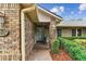 Covered brick porch with decorative door and manicured shrubs, providing a warm welcome to this charming home at 1810 Tamerlane Pl, Brandon, FL 33510