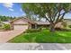 Charming single-story home with well-manicured lawn, mature trees, and brick-paved driveway leading to a two-car garage at 1810 Tamerlane Pl, Brandon, FL 33510
