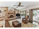 Comfortable living room featuring a brick fireplace, vaulted ceilings, and access to the pool area at 1810 Tamerlane Pl, Brandon, FL 33510