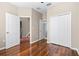 A bright bedroom featuring hardwood floors, closet space, and neutral paint at 2020 Greenwood Valley Dr, Plant City, FL 33563