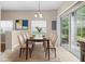 Staged dining area showcasing a glass table and comfortable seating near a window and sliding glass door at 2020 Greenwood Valley Dr, Plant City, FL 33563