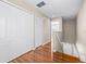 Upstairs hallway with hardwood floors, closet space, and access to the staircase at 2020 Greenwood Valley Dr, Plant City, FL 33563